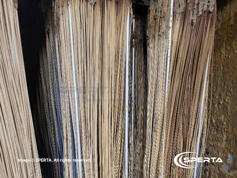 Surface fouling and sludge accumulation on MBR fibers due to high-strength wastewater conditions.